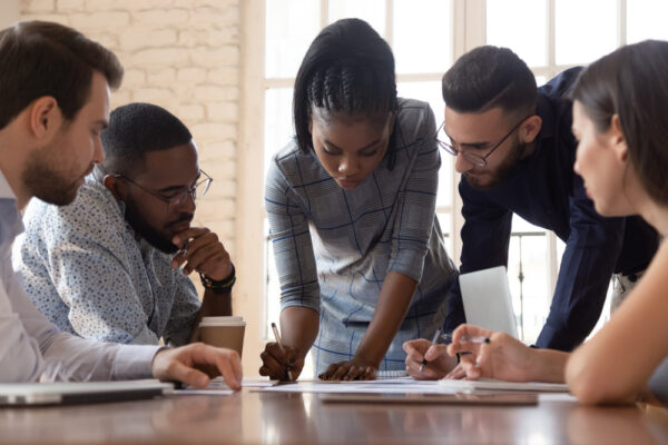 Focused,Arican,American,Millennial,Female,Team,Leader,Leaned,Over,Table,